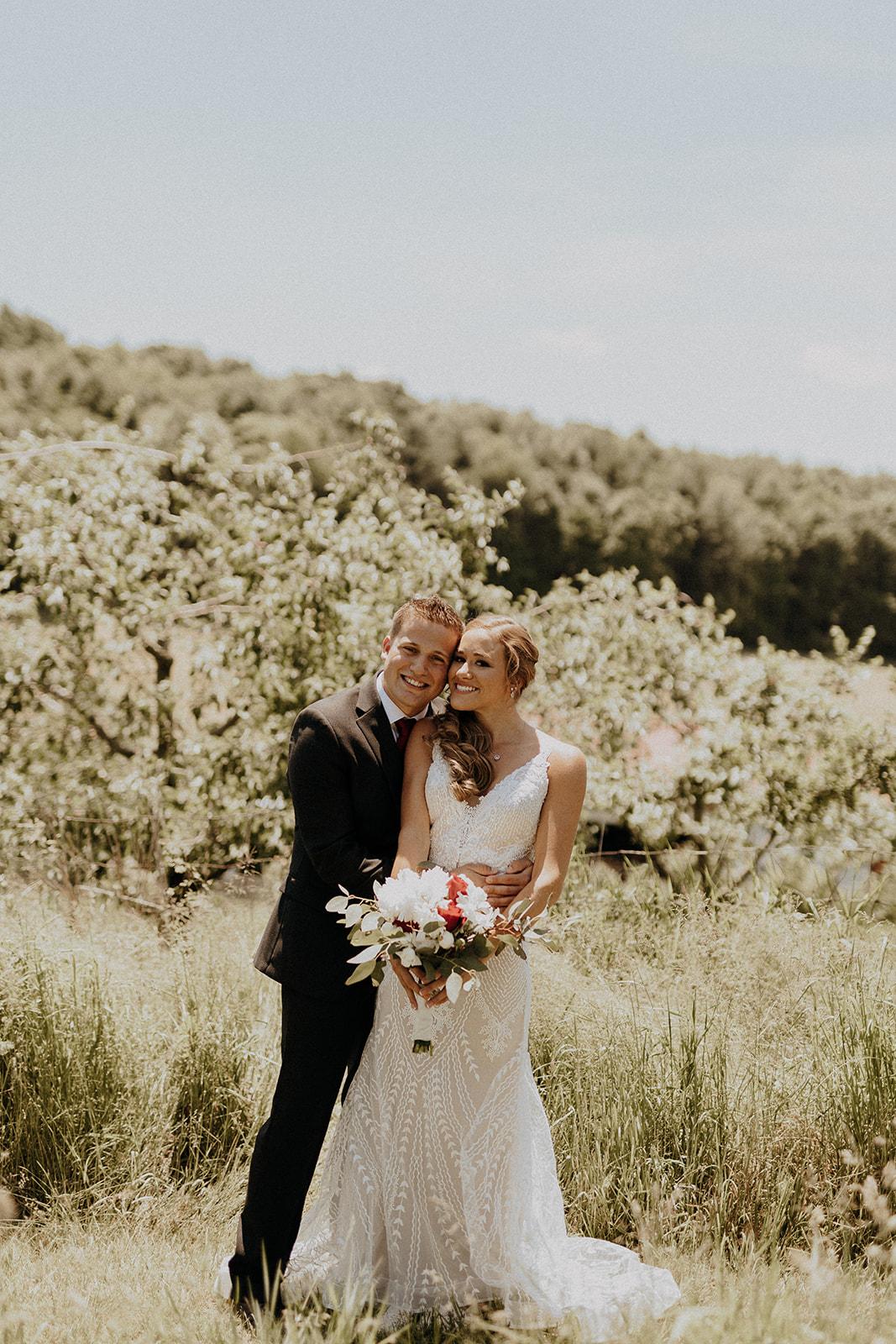 Aliyah Grace Burton Photography White Pine Grove Bride and Groom with Fruit trees backdrop
